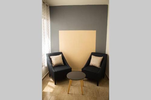 two chairs and a table in a room at Departamento Orellana 11 in Chetumal