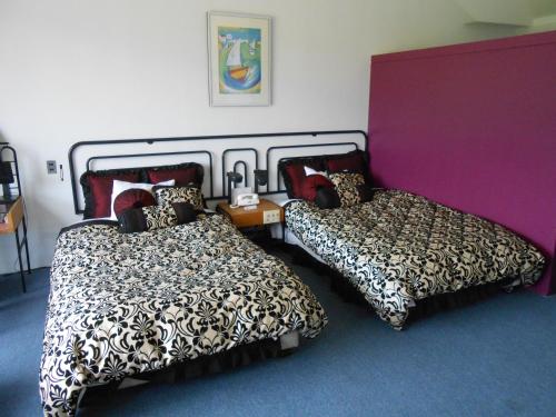 a bedroom with two beds and a purple wall at The Villa Hamanako in Kosai