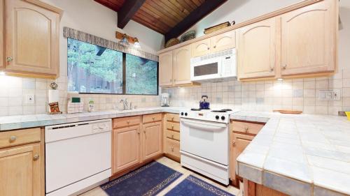 a kitchen with white appliances and wooden cabinets at Mammoth West #101 Condo in Mammoth Lakes