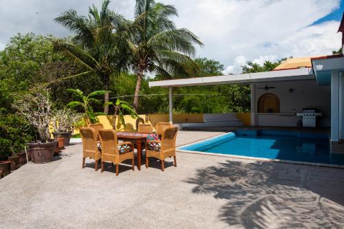 un patio con tavolo e sedie accanto alla piscina di Beach Access, Sleeps 9 Adults, Private Heated Pool, Boat Dock, Villa Calaveras a Nuevo Vallarta