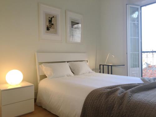 a white bedroom with a bed and a lamp at Room Atalaia - Bairro Alto in Lisbon