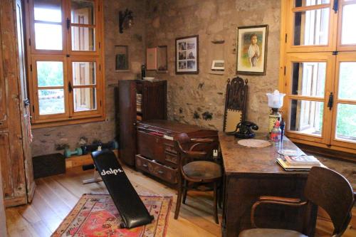 a room with a desk and a table and chairs at Stone House with Garden in Cunda/Ayvalik in Ayvalık