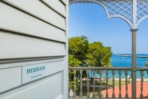 a white house with a sign that reads mermaid vacation home at Victoria House in Frederiksted