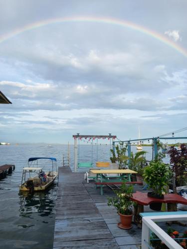 a dock with boats on the water with a rainbow in the sky at Nicol Aparment in Bocas del Toro