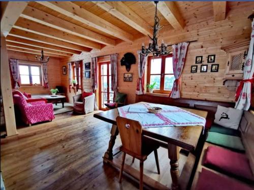 a dining room with a table in a log cabin at Marhütte in Ebene Reichenau