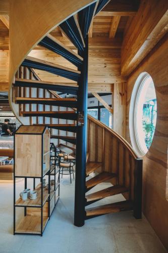 a spiral staircase in a wooden house with a round window at Family Tree Hotel in Krabi town