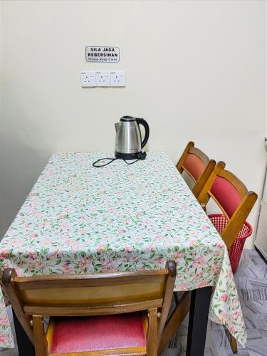 a table with a tea kettle on top of it at Homestay Tengku Maheran in Jitra