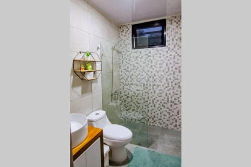 La salle de bains est pourvue de toilettes, d'un lavabo et d'une douche. dans l'établissement Hermoso apartamento, 3 Habitaciones espaciosas, 2 Aires acondicionados, à Santiago de los Caballeros