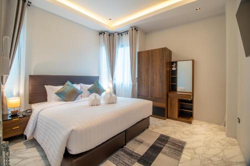 a bedroom with a large bed and a television at Coco Pina in Prachuap Khiri Khan