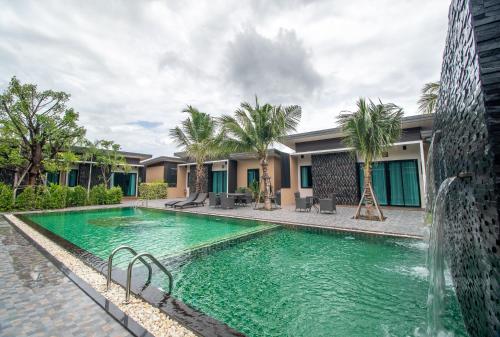a swimming pool in front of a building at Coco Pina in Prachuap Khiri Khan