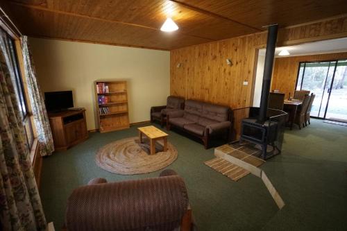 a living room with a couch and a stove at Karriwood Cottage in Pemberton