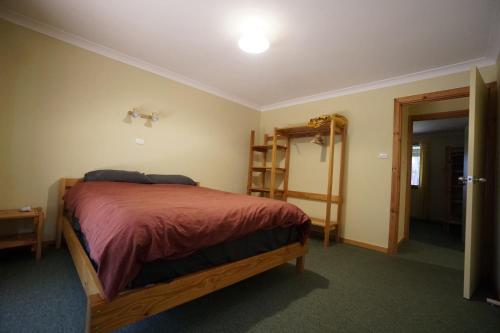 Un dormitorio con una cama y una escalera. en Karriwood Cottage, en Pemberton