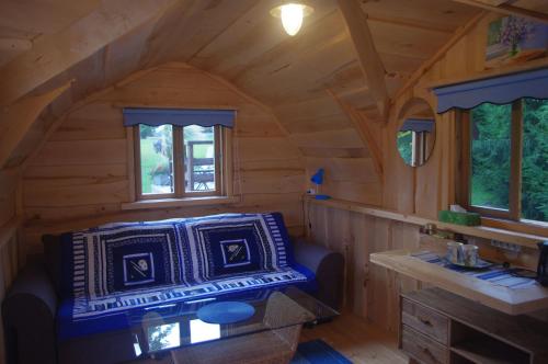 - un salon dans une cabane en rondins avec un canapé dans l'établissement Neitsijärve majutus, à Otepää