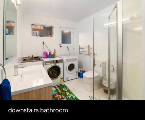 a bathroom with a washing machine and a sink at Spacious Utuhina holiday House in Rotorua