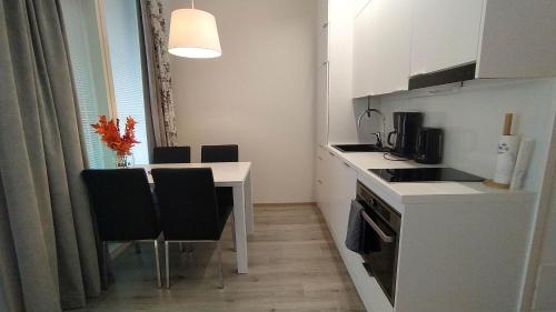 een keuken met een tafel en stoelen en een eetkamer bij Rovaniemi Cityhome Nordica in Rovaniemi