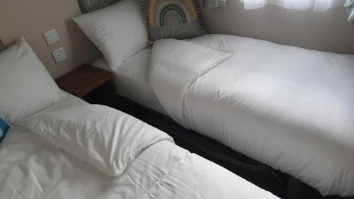 two beds sitting next to each other in a room at Kellys Holiday Homes 24 Willerby 2 bedrooms caravan in Weeley