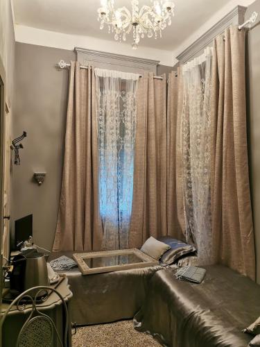 a room with a bed with curtains and a chandelier at L'Antico Lido Venice in Venice-Lido