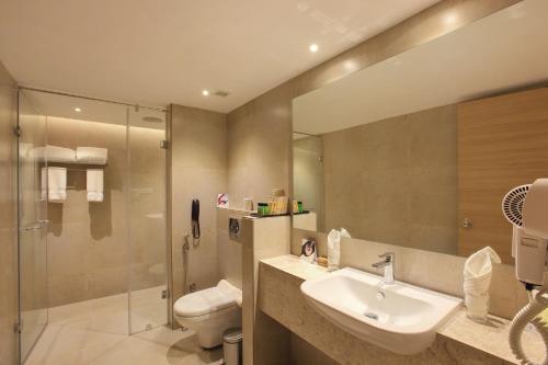 a bathroom with a sink and a toilet and a shower at Hotel Crystal Plaza in Ernakulam