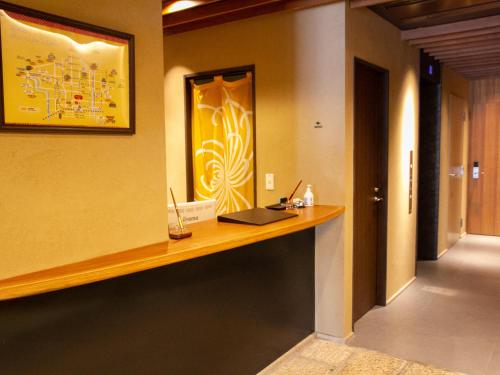 a reception desk in a room with a laptop on it at Hotel Rakurakuan in Kyoto