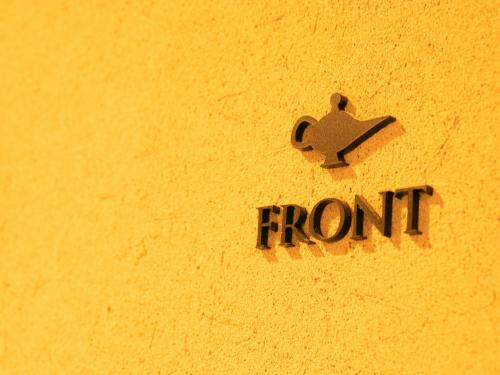 a sign that says front on a yellow wall at Hotel Rakurakuan in Kyoto