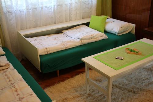 a bed and a table in a room with a bed and a coffee table at Green Cactus Rooms - unique and cozy house in Senta