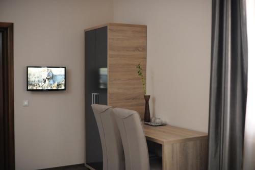 a room with a table and a tv on a wall at Pensiunea Lido in Piatra Neamţ
