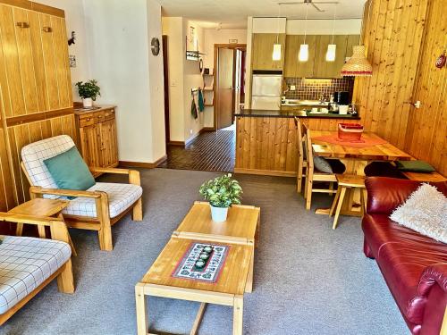 a living room with a couch and a table at 4 person apartment in central location in Morgins