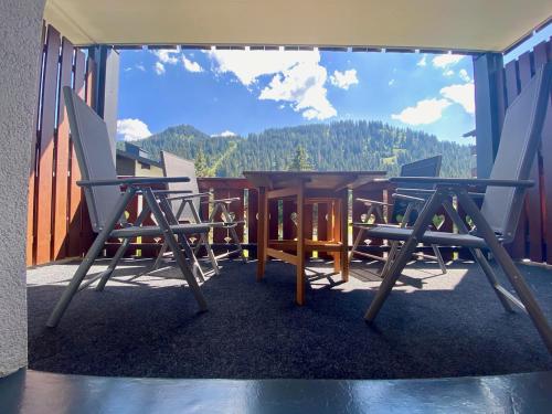 a patio with a table and chairs on a balcony at 4 person apartment in central location in Morgins
