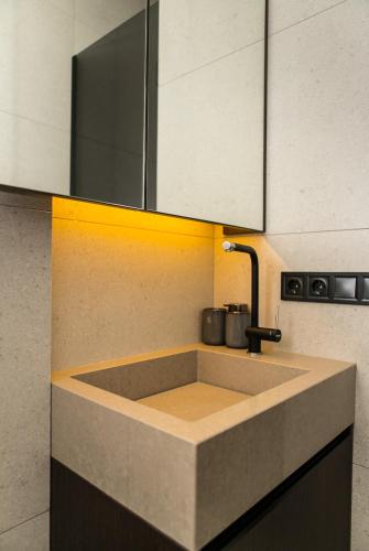 a kitchen counter with a sink and white cabinets at Пентхауз с террасой район Мост Сити in Dnipro