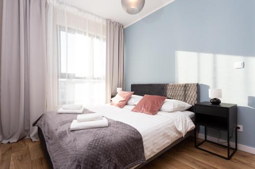 um quarto com uma cama grande e toalhas em City of the Kings - Indigo Apartment na Cracóvia