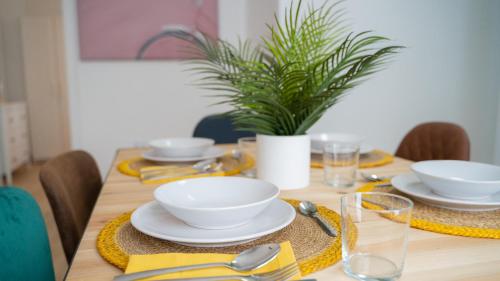 a dining room table with white bowls and plates on it at APARTAMENTO JUNTO A LA PLAYA DE BENIDORM in Benidorm