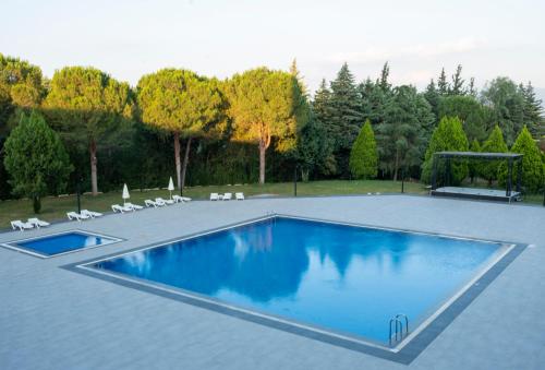 a swimming pool in a yard with chairs and trees at Euro Park Hotel Bursa Spa & Convention Center in Bursa