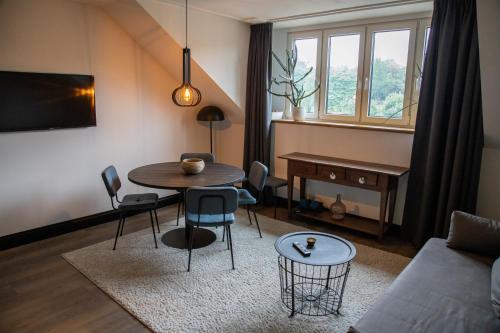 a living room with a table and a couch at Eigenheimer B&B in Simpelveld