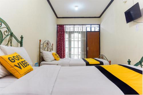 um quarto com 2 camas e uma janela em Astria Graha em Bandung