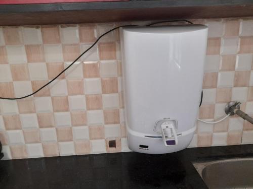 a white appliance on a wall next to a sink at Raaj Inn studio's in Candolim