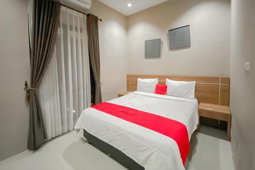 sypialnia z dużym łóżkiem i czerwonym kocem w obiekcie RedDoorz Premium @ Griya Inkoppabri Cisarua Puncak w mieście Bogor