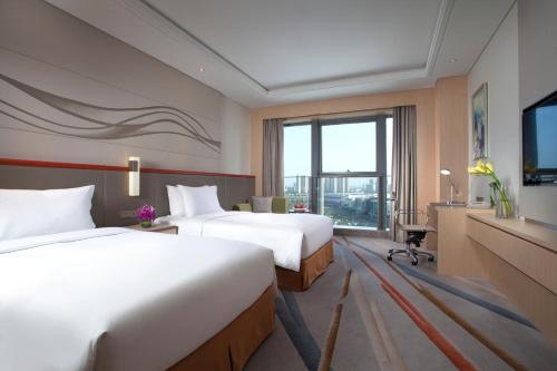 Habitación de hotel con 2 camas y TV en Holiday Inn Suzhou Huirong Plaza, an IHG Hotel en Suzhou