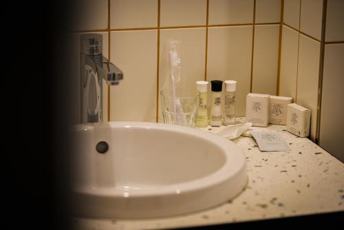 a bathroom counter with a sink and a bottle of soap at Pegard Andenne Centre in Andenne