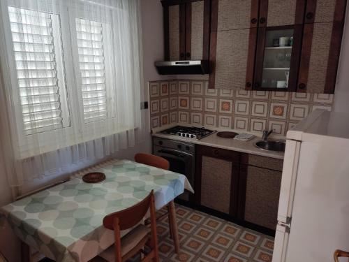 eine kleine Küche mit einem Tisch und einem Waschbecken in der Unterkunft Apartments Samec in Izola