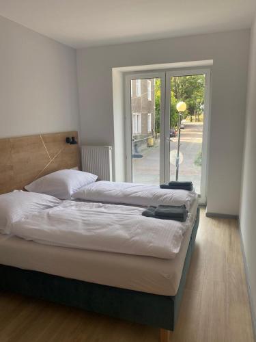 a bedroom with two beds and a large window at APARTAMENTY ZDROJOWA 9 in Duszniki Zdrój