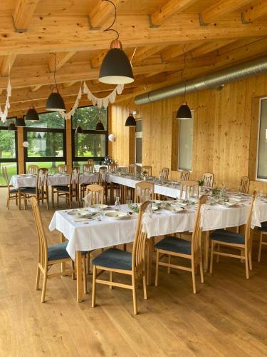 a dining room with white tables and chairs at Hotel Poutní Dům in Králíky