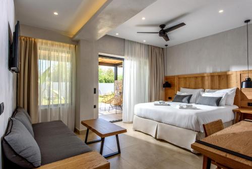AneSea Hotel في ماليا: غرفة نوم بسرير ابيض كبير واريكة