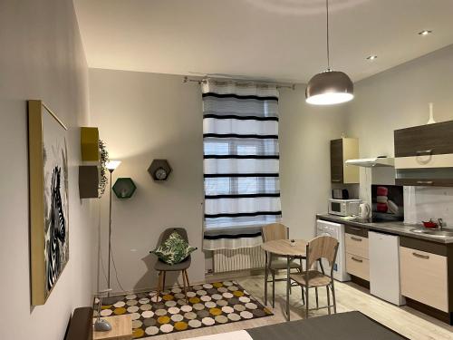 een keuken met een tafel en stoelen in een keuken bij Studio Elizabete 3 in Rīga