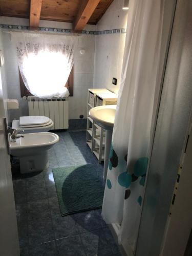 uma casa de banho com 2 lavatórios, um WC e um chuveiro em Cá Greta em Chioggia