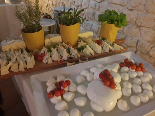a table topped with cheese and tomatoes and potted plants at ABBAZIA SS. QUIRICO E GIULITTA in Micigliano