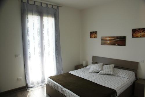 una camera con un letto e una grande finestra di Il Nuovo Palazzotto a Stresa