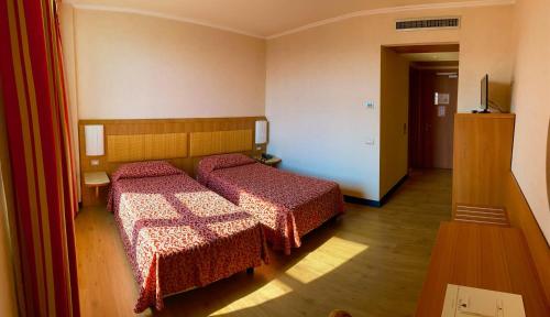 a bedroom with two beds with red comforters at Nicotel Barletta in Barletta