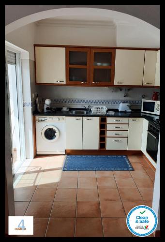 a kitchen with white cabinets and a washing machine at HOME4U - Fantastic 2 bedroom apartment, with pool in Cabanas de Tavira