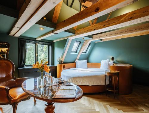 a bedroom with a bed and a table and chairs at Boutique Hotel The Noblemen in Amsterdam