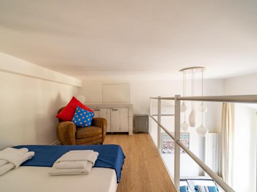 um quarto com uma cama e uma cadeira em The Best Rent - Lovely loft with balcony near Piazza Vetra em Milão